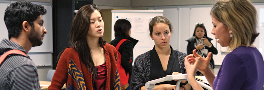 Decorative image of a professor speaking to three students.